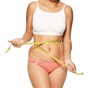 Gadis yang berlebihan berat badan mengukur pinggangnya
